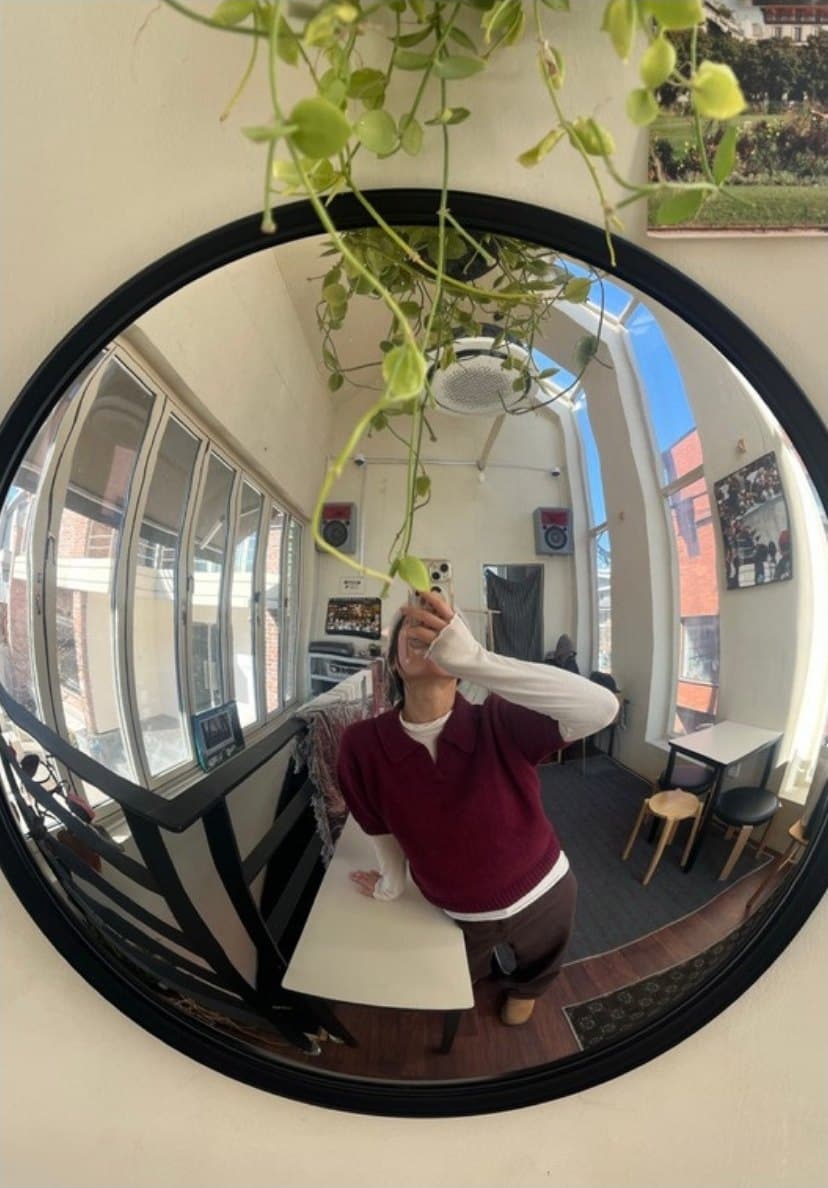 Dabin reflected in a round mirror at a neighbourhood cafe