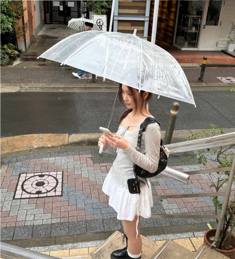 Jiyun with a clear umbrella on a rainy street